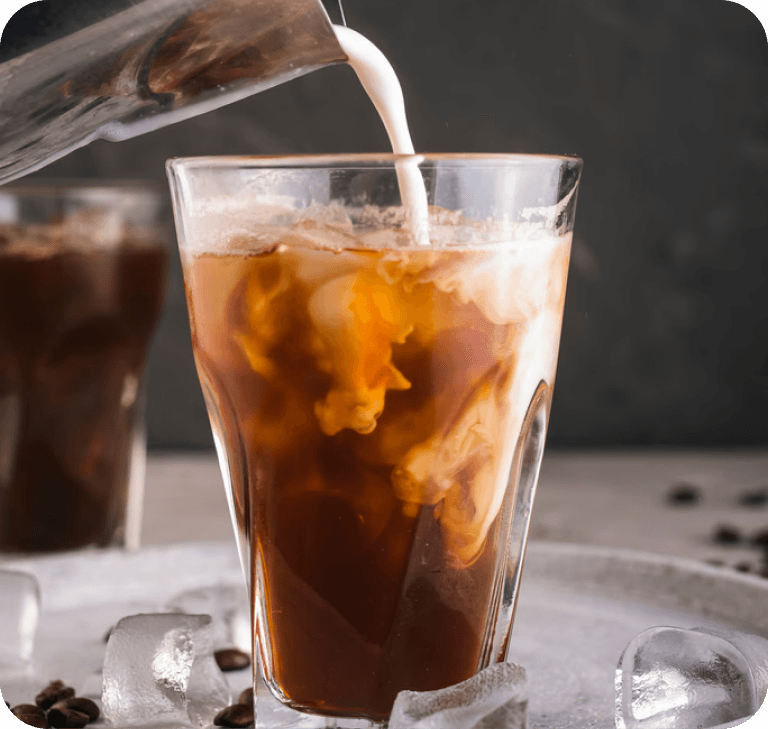 Milk swirling into iced coffee